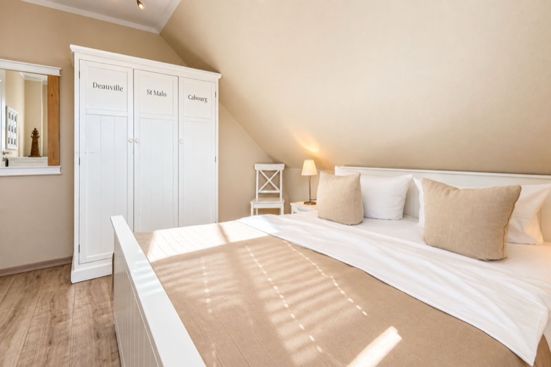 Schlafzimmer mit großem Doppelbett unter der Dachschräge