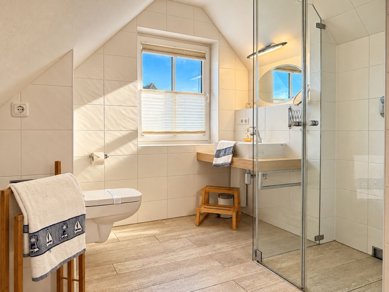 Helles Badezimmer mit bodengleicher Glasdusche